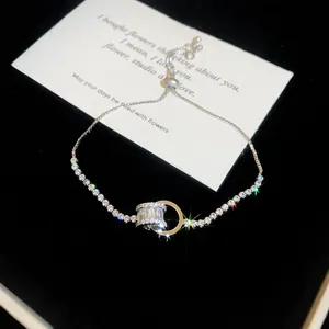 Détail du bracelet réglable en zircon avec anneaux imbriqués sur fond de velours.