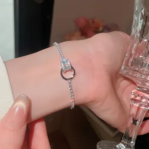 Gros plan d'un bracelet minimaliste en zircon avec cercles entrelacés sur le poignet d'une femme