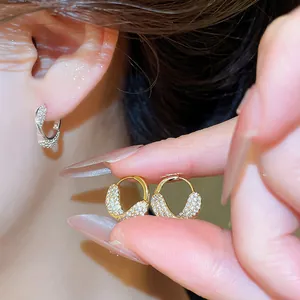 Gros plan exquis de boucles d'oreilles créoles serties de zircons étincelants
