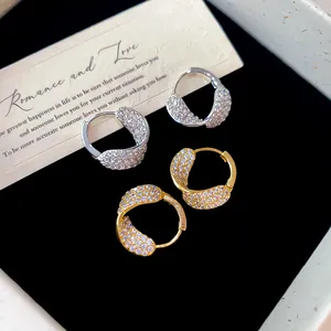Zoom sur des boucles d'oreilles créoles françaises en zircon argenté et doré