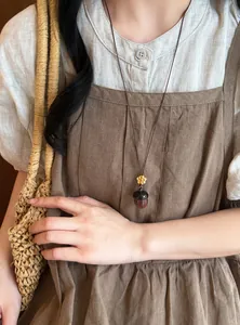 Collier vintage en bois avec pendentif gland et petite fleur jaune sur un long cordon