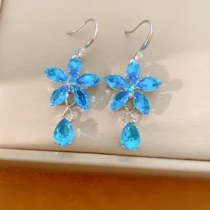 Nahaufnahme eleganter blauer Zirkonia-Ohrringe in Blumenform mit Kristalltropfen