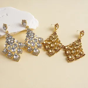 Detailansicht von eleganten silbernen und goldenen Strass-Ohrringen in Tropfenform