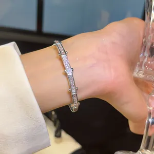 Close-up van 18K vergulde zirkonia armband gedragen om een pols met fonkelende steentjes