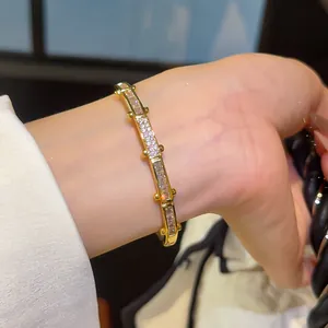 Detailweergave van een luxe 18K vergulde armband met vierkante zirkonia gedragen om de pols