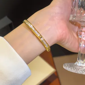 Detailopname van een luxe 18K vergulde armband met fonkelende zirkonia-stenen om de pols.