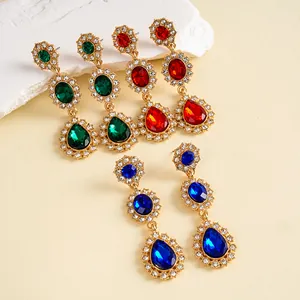 Vue détaillée de boucles d'oreilles vintage en forme de goutte avec cristaux verts, rouges et bleus.