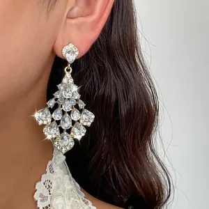 Exquisites Detail eines goldfarbenen Kronleuchter-Ohrrings mit brillanten Birnen-Kristallen
