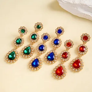 Vue détaillée de boucles d'oreilles rétro dorées avec cristaux verts, bleus et rouges