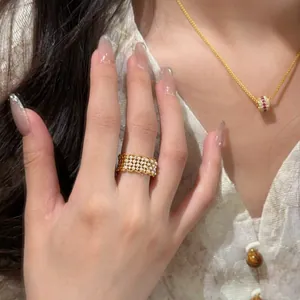 Detailed view of 18k gold plated pearl ring with elegant lace design on model finger