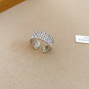 Detailed macro view of a silver-toned hollow lace open ring with pearls and zircons