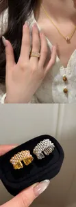Macro view of detailed 18k gold plated hollow lace ring decorated with elegant pearls