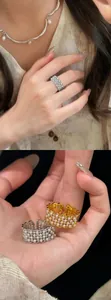 Close-up of 18k gold plated zircon open ring featuring pearl lace details on finger