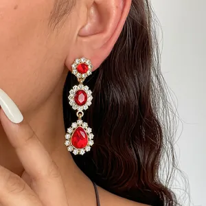 Vue détaillée de boucles d'oreilles vintage dorées avec cristaux rouges et gouttes
