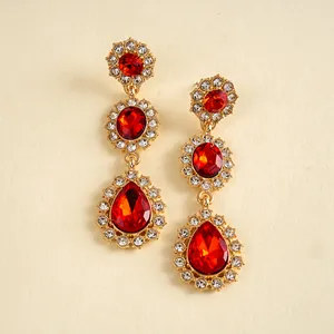 Vue détaillée des boucles d'oreilles vintage dorées avec des cristaux rouges en forme de goutte