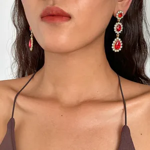 Élégantes boucles d'oreilles vintage avec pierres rouges et cristaux sur modèle