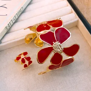 Nahaufnahme eines Armreifs und Rings mit roten Emaille-Blumen-Design