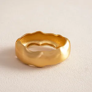 Detailed close-up view of a minimalist matte gold irregular twisted geometric bangle bracelet