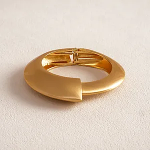 Close-up detail view of a minimalist matte gold irregular geometric cuff bracelet with hinge