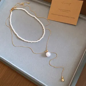 Détail élégant d'un ensemble de colliers de perles de luxe français et pendentif doré