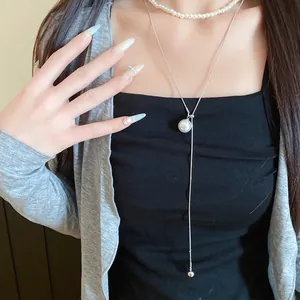 Gros plan d'un ensemble de deux colliers de perles de style français sur un modèle