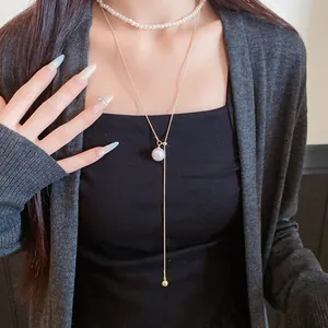 Gros plan d'un ensemble de deux colliers en perles et pendentif doré de style français