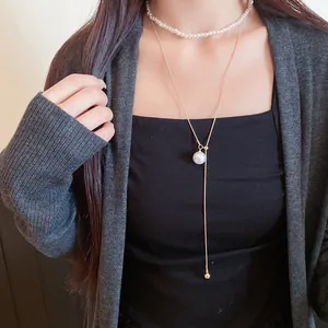 Gros plan d'un ensemble de colliers élégants à deux couches en perles et en or