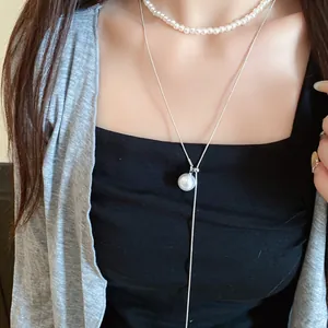 Détail d'un ensemble de colliers de perles de style français avec une chaîne à pendentif