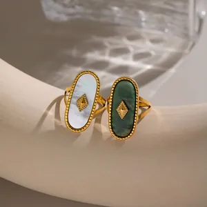 Nahaufnahme von ovalen 18K vergoldeten Vintage-Ringen mit weißen und grünen Natursteinen