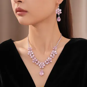 Elegant jewelry set with pink zirconia flower and teardrop pendants worn by model