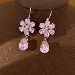 Macro view of elegant pink zircon flower earrings with sparkling water-drop shaped pendants