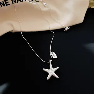 Detailed view of a silver starfish pendant necklace with LUCKY engraved tag accent