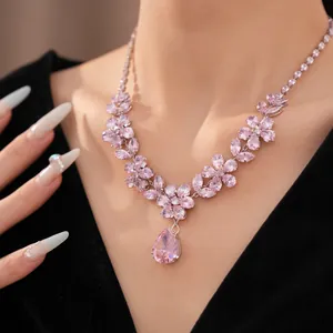 Close-up of a sweet pink zircon flower necklace with a large teardrop pendant on a model.
