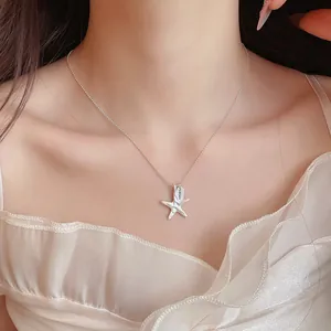 Macro view of minimalist silver wrinkled starfish pendant necklace with LUCKY charm