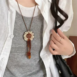 Vintage bohemian necklace with brown acrylic beads and woven pendant on a leather cord