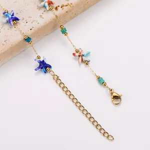 Detailaufnahme der Seestern-Anhänger aus Edelstahl und Perlen an einer Goldkette.
