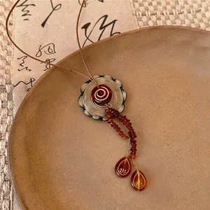 Macro detail view of a vintage style acrylic pendant necklace with brown beads and charms