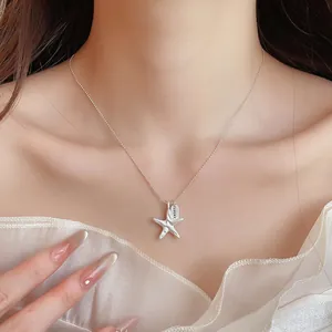 Close-up of minimalist silver starfish pendant necklace with LUCKY tag on model's neck.