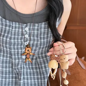 Detailed view of handcrafted wooden bear pendant necklace and animal keychains
