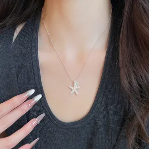 Close-up of a silver wrinkled star pendant necklace with 'LUCKY' tag on a female model