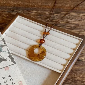 Close-up of the retro amber acrylic round pendant necklace with brown leather cord