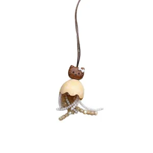 Handmade wooden cat pendant necklace featuring beaded tassels and a brown leather cord