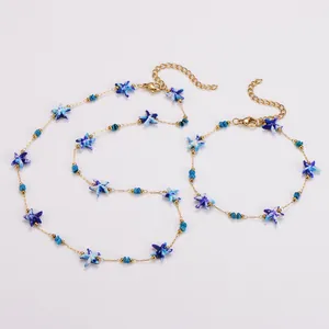 Detailansicht von blauen Seestern-Anhängern an einer goldenen Edelstahlkette