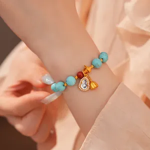 Nahaufnahme des Perlenarmbandes mit türkisfarbenen Steinen und goldenem Zirkonia-Anhänger