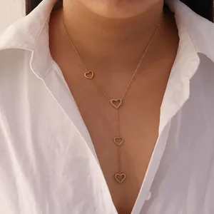 Stainless steel gold Y-shaped necklace with four pavé heart charms shown on a female model