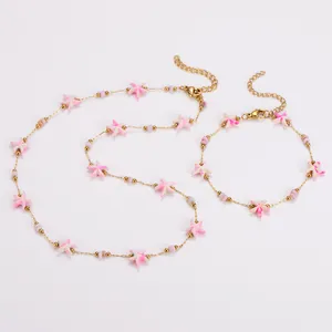 Set aus Halskette und Armband mit rosa Seesternen an einer goldenen Edelstahlkette