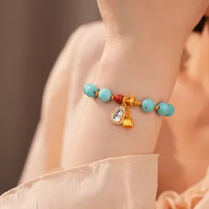 Detailansicht eines Vintage-Perlenarmbands mit goldenem Flaschenkürbis-Anhänger und Türkis