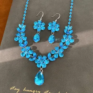 Dettaglio ravvicinato del set collana e orecchini a fiore con zirconi blu brillanti.