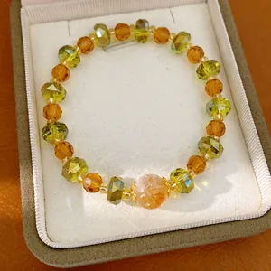 Vue détaillée d'un bracelet de luxe en perles de verre à facettes ambre et vertes