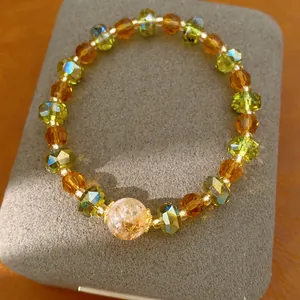 Vue détaillée d'un bracelet en perles de verre facettées avec des pierres ambre et vert